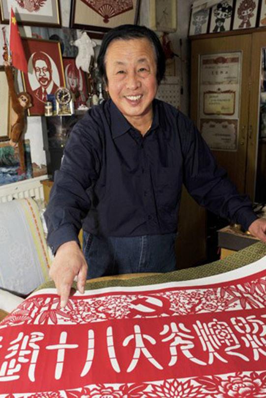 张晓林用时四天制作出一幅"喜迎十八大光辉照万家"的剪纸作品